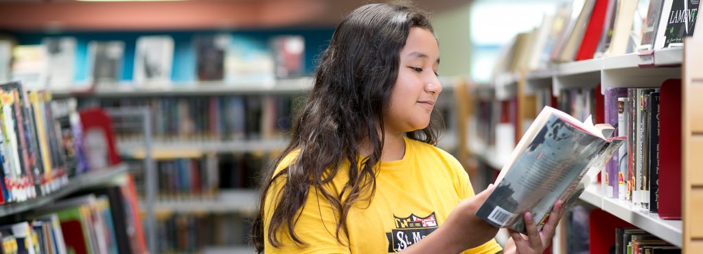 teen girl in yellow shirt reading a book