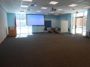 Picture of empty Lexington Park meeting room B with projector screen at front