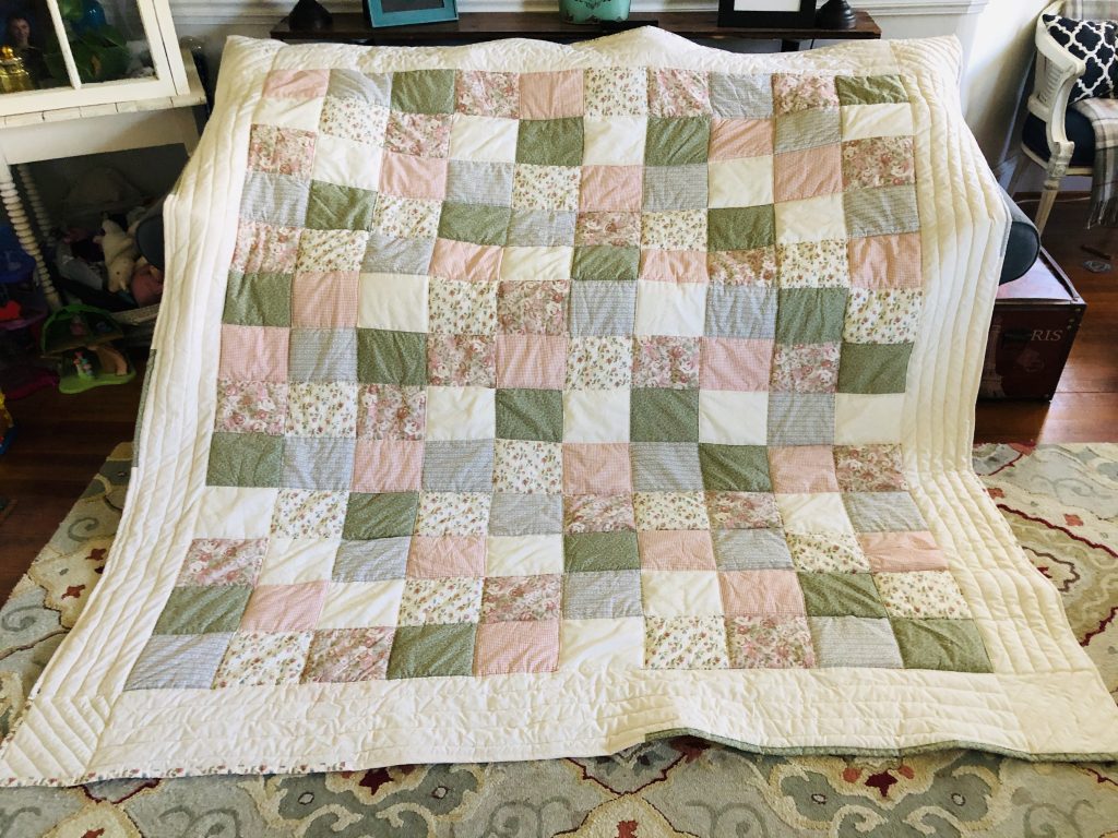 photo of a quilt in cream, green, blue, pink