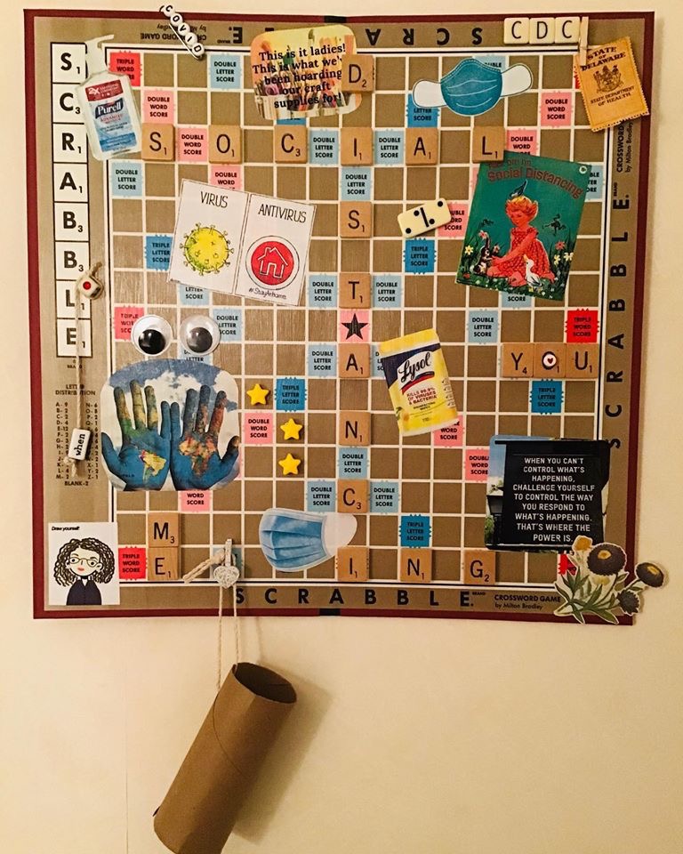 A scrabble board with tiles spelling out social distancing