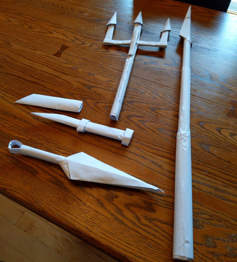 origami knives, a sword, and a trident made of white folded paper