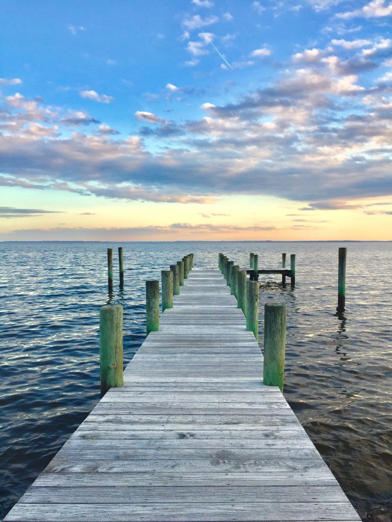 Photo of a pier and a sunset over a body of water