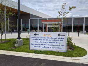 Front of the Library with a large sign with arrows pointing left