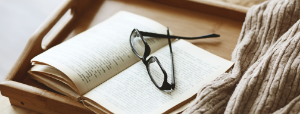 an open book with a pair of glasses sitting on it