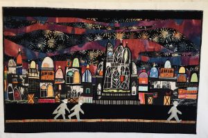 quilted scene of a town with two people walking down the street