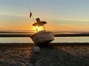 A boat on the beach at sunset