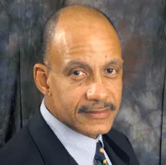 Headshot of FJ Talley, a Black man with a mustache wearing a suit and tie