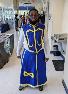 Black man dressed in a purple and gold costume