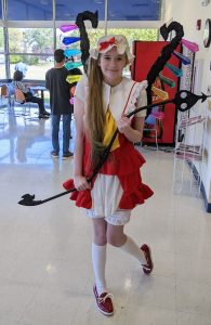 Girl dressed in a red and white outfit with black wings with colored jewels