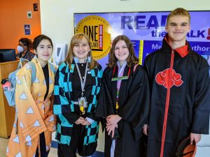 Four teenage cosplayers in robes of different colors
