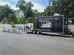 Grill Sergeant BBQ food truck, open for business, with tables set up next to it
