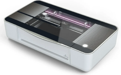 Tabletop Glowforge laser cutter, with a white base and clear top to view the cutting process