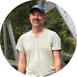 Jerry Gabriel stands on a bridge with trees in the background