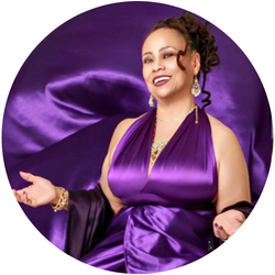 Aurba Love, wearing a purple dress, smiles at the camera