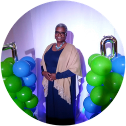 J.G. Pressley stands between two sets of green and blue balloons