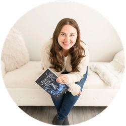 Kimberly Rison sits on a couch holding her book Arrow's Align