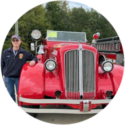 John Tippett stands next to a historical fire truck