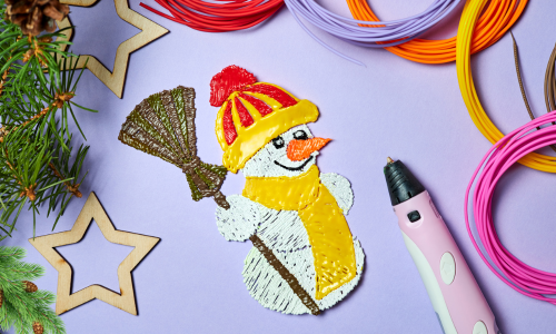 A snowman created with a 3D pen wearing a yellow scarf and hat and holding a broom, with the 3D pen and filament pieces next to it 