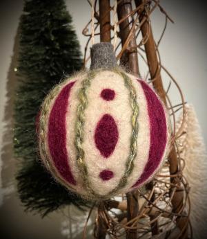 A felted ball ornament in red, white, and green
