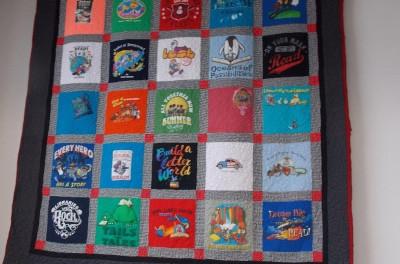 A five by five square quilt made of colorful t-shirt designs