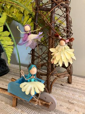 Three fairies made of  fake flower petals, wood beads, embroidery floss, tacky glue, and wrapped wire