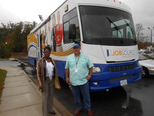 photo of a man and a woman standing in front of the Mobile Career Center RV