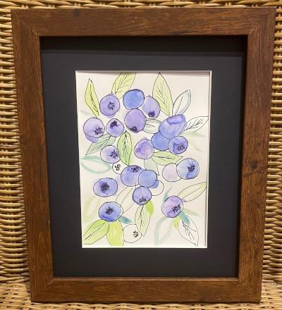 A framed watercolor of blueberries and leaves